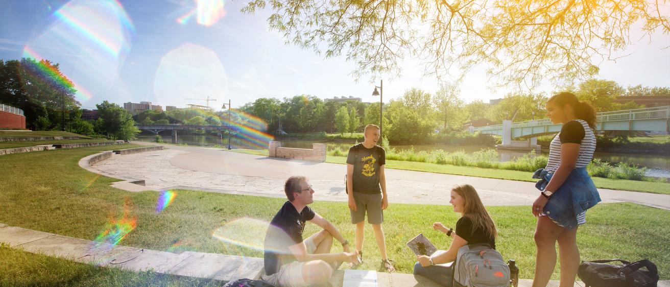 students by the river next to the IMU